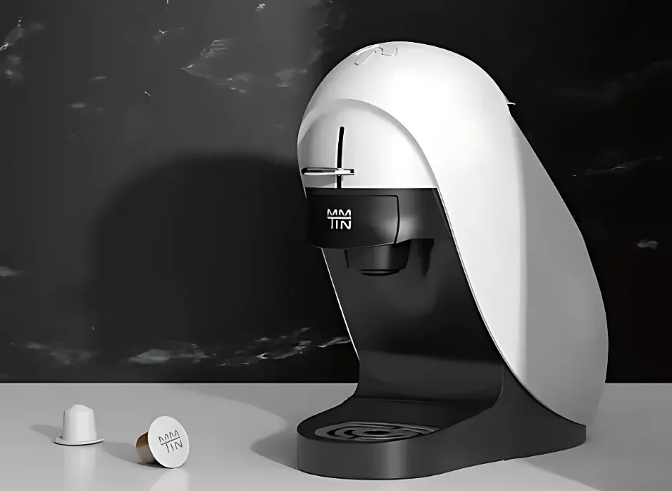 Modern coffee maker with capsules on counter.